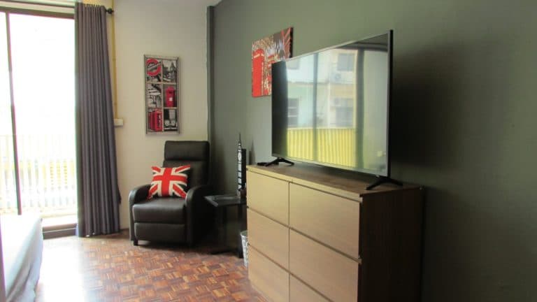 Home Stay 9 a flat screen tv sitting on top of a wooden dresser